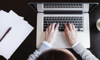 Overhead shot of a businessman typing on his apple mac at his clean desk